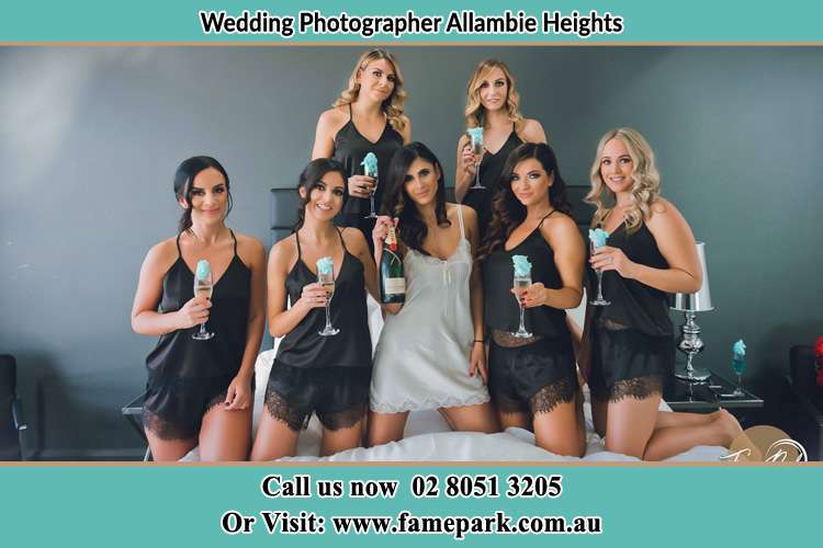 Photo of the Bride and the bridesmaids wearing lingerie and holding glass of wine on bed Allambie Heights NSW 2100