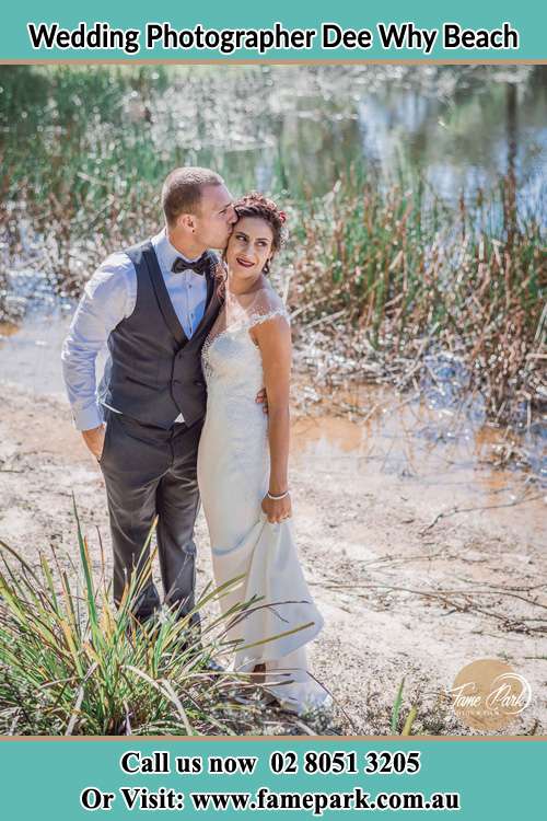 Photo of the Groom kiss the Bride near the lake Dee Why Beach NSW 2099