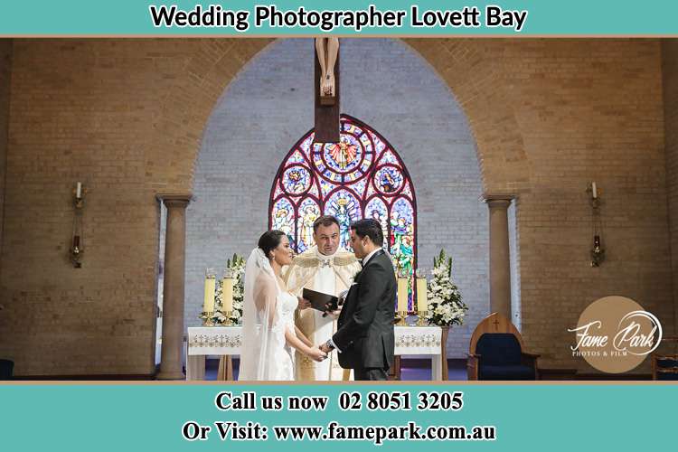 Photo of the Bride and the Groom with the Priest at the altar Lovett Bay NSW 2105