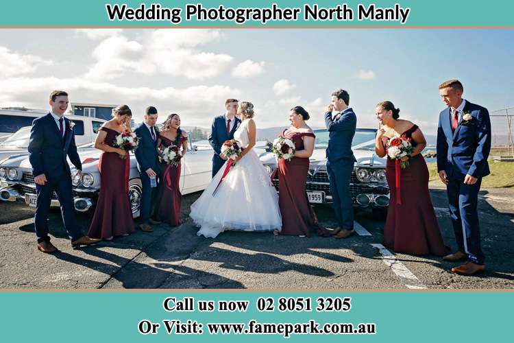 Photo of the Groom and the Bride kissing with the entourage North Manly Beach NSW 2100