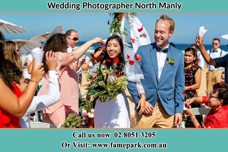 Photo of the Bride and the Groom showering flower petals by the visitors North Manly Beach NSW 2100